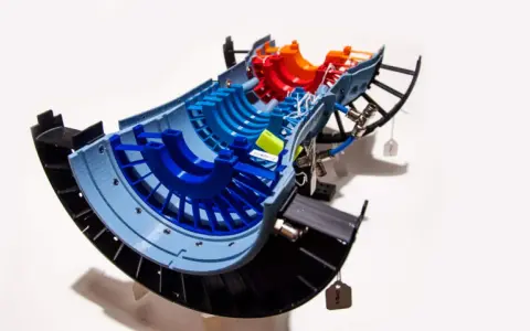 A colorful 3D printed model of a jet engine turbine, showcasing advancements in 3D printing aerospace technology.