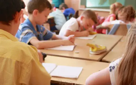 Bambini in classe studiano, un esempio di come le scienze pedagogiche cos'è, osservando l'apprendimento.