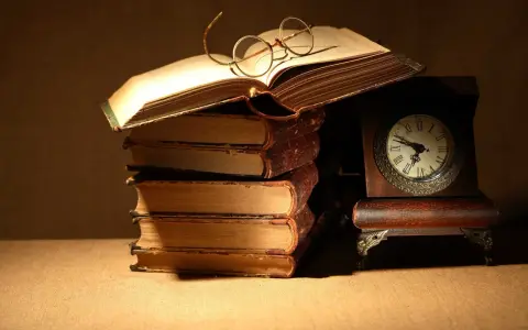 Un libro aperto con occhiali da lettura, una pila di antichi volumi e un orologio da tavolo. Un invito a leggere Catullo: "dammi mille baci".