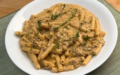 Piatto di pasta alla montecarlo con ragù cremoso e timo fresco.