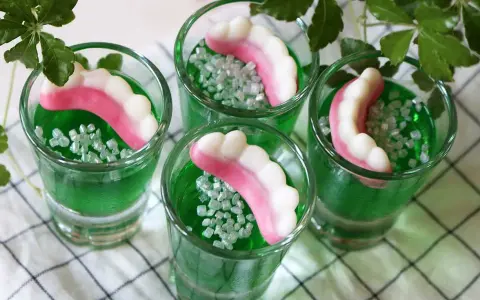 Gröna jello shots med godiständer och strössel. Perfekt för en festlig stämning!