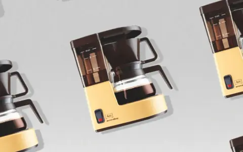 Retro-Kaffeemaschine in Gelb und Braun, bereit, köstlichen Kaffee zu filtern.