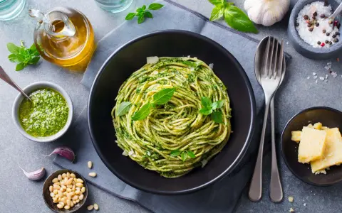 Pyszny obiad bez mięsa: spaghetti z pesto, świeżą bazylią, orzeszkami pinii i parmezanem.