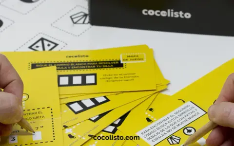 Manos resolviendo juegos para comida de empresa con tarjetas amarillas y lápices. ¡Diversión garantizada!