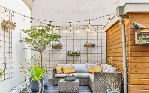 Piccole verande arredate con divano, tavolino e piante. Luci decorative creano un'atmosfera accogliente.