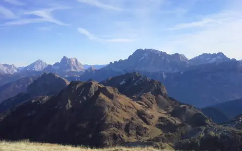 Panorami alpini mozzafiato, con cime innevate e pendii bruni. Un passo staulanza ideale per un'escursione.