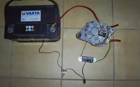 Schemat podłączenia regulatora napięcia do prądnicy C-330: akumulator, prądnica, przełącznik i żarówka.