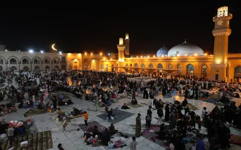 Menschen versammeln sich nachts auf einem Platz vor einer Moschee, um die Qadr Nacht zu begehen.