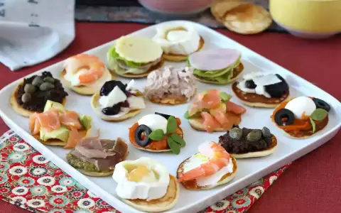 Plateau de blinis garnis de crevettes, saumon, fromage de chèvre, tapenade, jambon et autres délices.