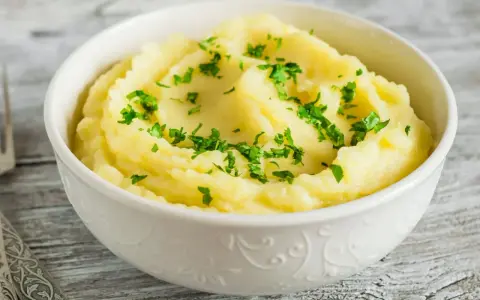 Puszyste, kremowe puree ziemniaczane, posypane świeżą natką pietruszki. Idealny dodatek do obiadu, który pokazuje, jak zrobić puree.