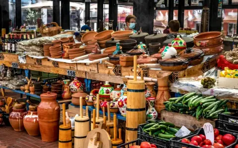 Stoisko z ceramiką, butelkami wina i świeżymi warzywami. Idealne miejsce, by zastanowić się, co przywieźć z Albanii – gliniane naczynia, lokalne produkty czy rękodzieło.