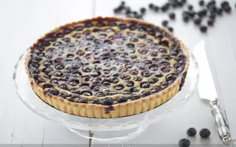 Tarta de arandanos casera, con masa dorada y arándanos jugosos, lista para disfrutar.