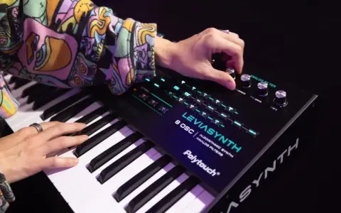 Ręce grają na syntezatorze LEVIASYNTH, tworząc dźwięki, które mogą wywołać efekt glitch sound.