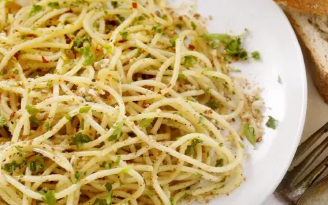 Un piatto di spaghetti conditi con aglio, olio, peperoncino e prezzemolo, un classico della pasta alla carrettiera.