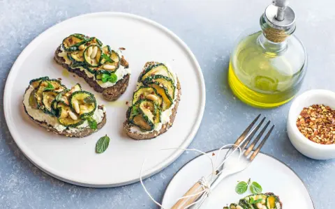 Bruschetta con zucchine grigliate, ricotta e pinoli, condita con un filo d'olio.