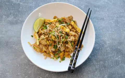 Pyszny pad thai przepis z kurczakiem, jajkiem, orzeszkami i limonką. Idealny na szybki obiad.
