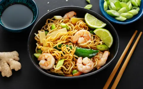 Makaron chow mein z krewetkami, warzywami i limonką, podany z sosem sojowym i imbirem.