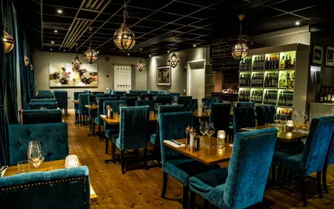 Elegant restaurang med sammetsklädda stolar och vinkyl. En av många bra restauranger i Uppsala för en fin middag.