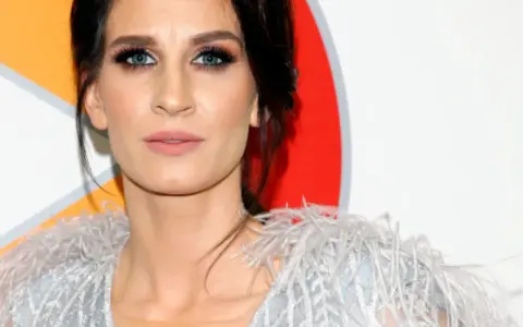 Sylwia Grzeszczak z niebieskimi oczami i w zwiewnej kreacji, jakby szukała słów na k.