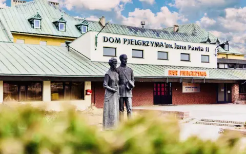 Pomnik przed Domem Pielgrzyma im. Jana Pawła II. Sprawdź ceny i godziny otwarcia baru.