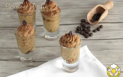 Delizioso spumone al caffè in bicchierini, guarnito con chicchi di caffè e cacao. Perfetto per una pausa golosa.