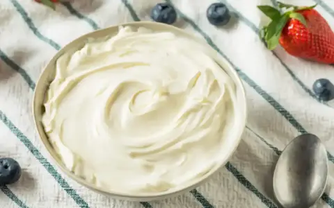 Un bol de chantilly mascarpone onctueuse, garni de fraises et de myrtilles. Parfait pour un dessert léger.