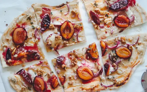 Flammkuchen mit Pflaumen, Zwiebeln und Walnüssen. Ein köstlicher Flammkuchen Belag, der süß und herzhaft kombiniert.