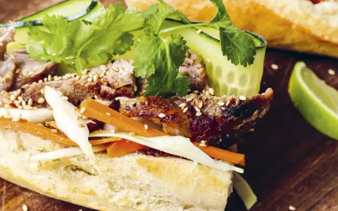 En saftig banh mi med grillat kött, krispiga grönsaker och sesamfrön. Ett perfekt banh mi recept för en smakrik lunch.