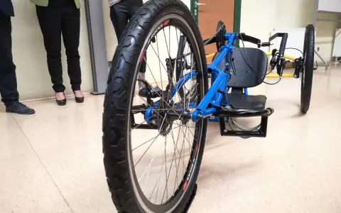 Niebieski prototyp roweru trójkołowego z dużym tylnym kołem i siedzeniem.