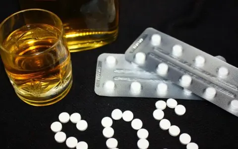 Szklanka alkoholu i blistry z tabletkami. Czy to pytanie o benzodiazepiny co to?