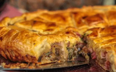 Une tourte dorée, garnie de champignons et de lardons, un délice de la saumur cuisine.