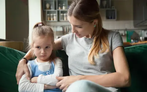 Mama próbuje uspokoić obrażone dziecko, które nie chce słuchać.