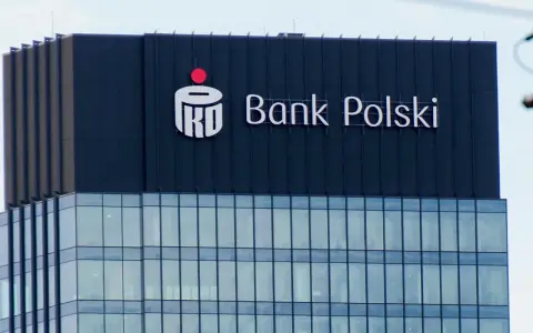 Logo PKO BP na ciemnym budynku. Widoczny napis "Bank Polski".