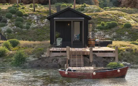 Svart stuga vid vattnet med altan och båt. Kanske behövs bygglov altan för denna idylliska plats.
