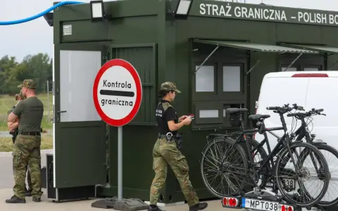 Strażnicy graniczni prowadzą kontrole na granicy niemieckiej. Obok zielonego punktu kontrolnego stoją dwa rowery na bagażniku samochodu.