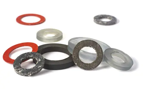 Ensemble de rondelles de différentes tailles et couleurs, dont un joint moulé rouge, gris et noir, sur fond blanc.