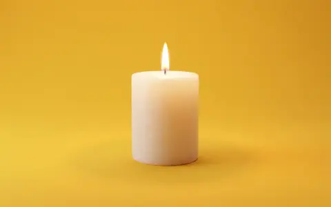 Brennende Kerze auf gelbem Hintergrund. Sie symbolisiert Hoffnung und Trost, was bei der Frage nach dem welcher pflegegrad bei palliativ wichtig ist.