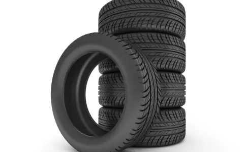 Pile de pneus de voiture noirs sur fond blanc.