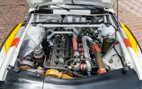 Silnik Audi quattro S1, potężna jednostka z turbosprężarką i licznymi przewodami, gotowa do rajdowych wyzwań.