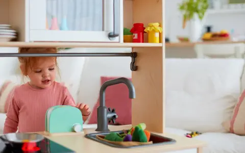 Mała dziewczynka bawi się w kuchni, przygotowując posiłek. To idealny hit na roczek dla małego kucharza!