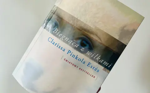 Książka "Biegnąca z wilkami" Clarissy Pinkoli Estés, światowy bestseller, z fragmentem oka na okładce.