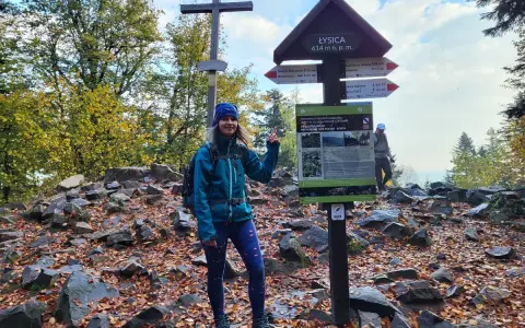 Kobieta na szczycie Łysica, 614 m n.p.m., przy drogowskazie. Jesień na szlaku.