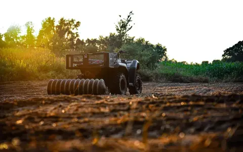 ATV with a roller attachment, ready for field work. This is one of many tractor attachments that can help prepare the soil.