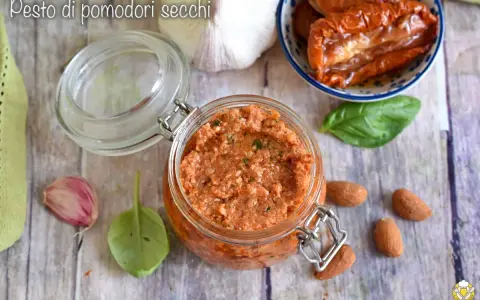 Un vasetto di pesto di pomodori secchi, con mandorle, aglio e basilico, pronto per insaporire i tuoi piatti.