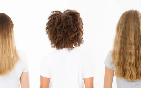 Drei Frauen von hinten: glattes, gefärbtes Haar; lockiges Haar mit hoher Porosität; welliges, blondes Haar.