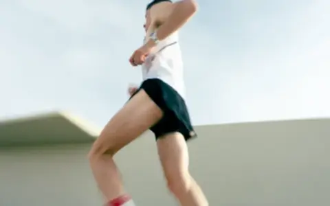 Un atleta corre a tutta velocità, mostrando quanto corre veloce un uomo. Le gambe muscolose si muovono rapidamente, catturando l'essenza della velocità.