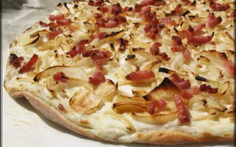 Flammekueche croustillante, garnie d'oignons et de lardons. Une recette facile pour un plat savoureux.