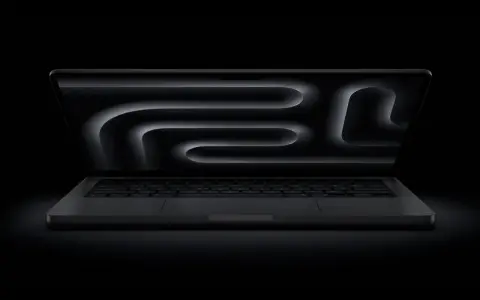 MacBook Pro z polskim układem klawiatury, ciemny ekran z abstrakcyjnym wzorem.