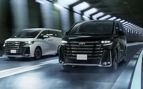Dwa luksusowe minivany Toyota Vellfire jadące w tunelu.