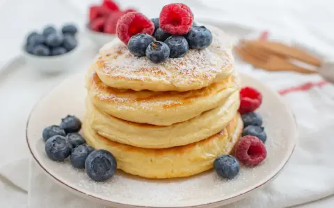 Puszyste pancakes z jagodami i malinami, idealne na zdrowe śniadanie. Ten przepis na zdrowe pancakes zachwyci każdego!